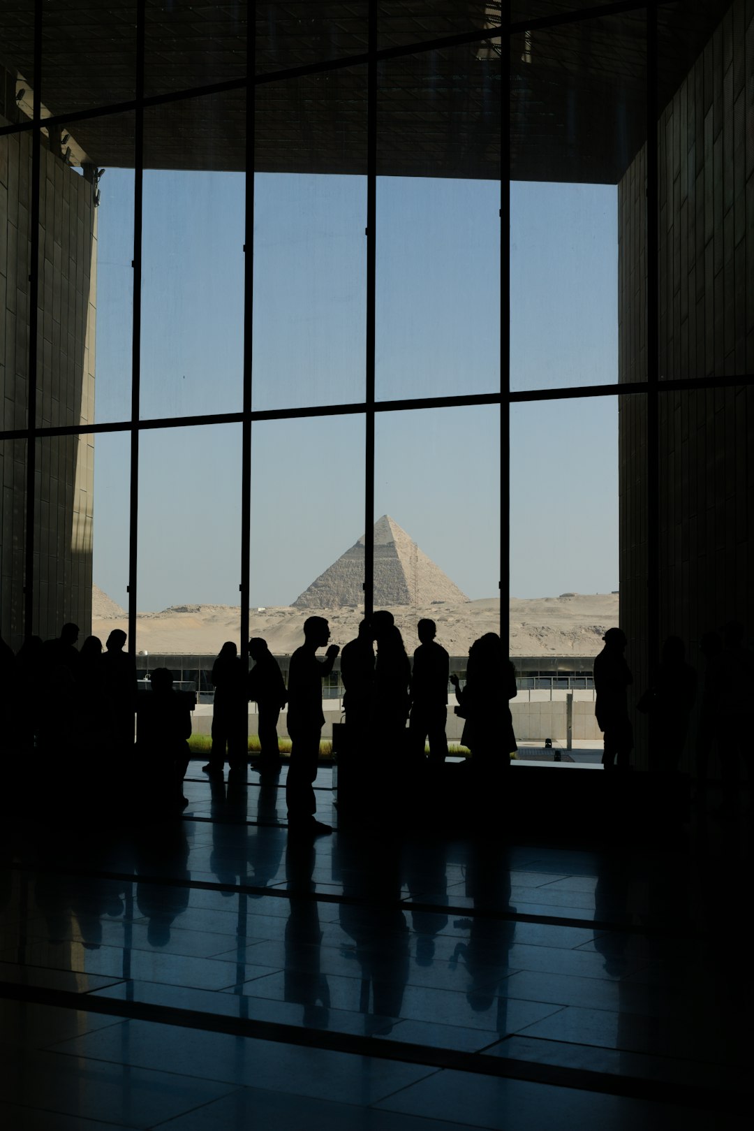 Visitors silhouetted against the Giza plateau from GEM